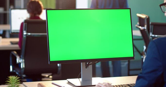 Close up of monitor in office. Green screen. Employee works on computer, types text, enters data into the database. Chromokey.