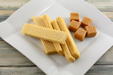 Caramel wafer cookies with caramel candy squares on white dessert plate