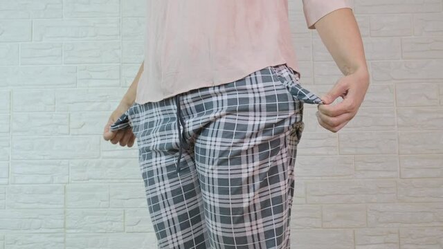 Poor person, woman showing empty pockets without money, moneyless and jobless concept