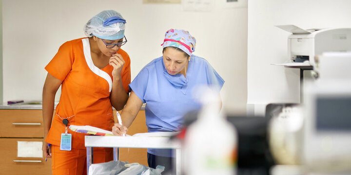 Nurses checking records and schedule about a patient