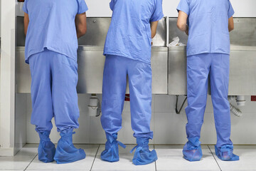 Three doctors and nurses washing their hands in a hospital