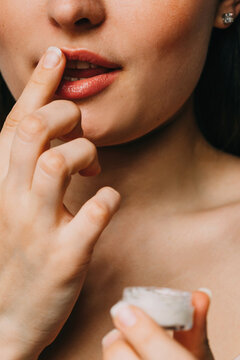 Woman applying balm on lips