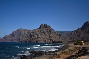 Furgoneta camper aparcada en el acantilado de una playa de las islas Canarias