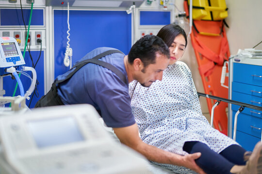 Nurse assistant in the ICU helping a young female patient