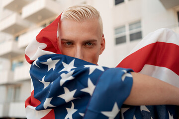 Stylish blond man with an american flag in hand