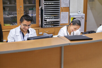 Two happy doctors working with their computers
