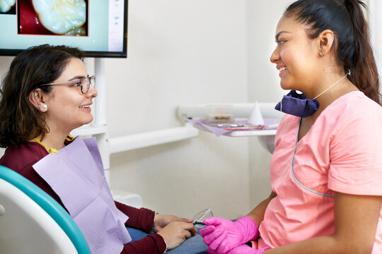 Friendly chat with dentist and her patient after a procedure