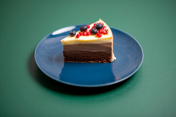chocolate cake on a blue plate on a green background