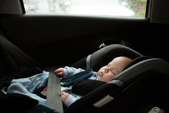 Two month baby sleeping in safety seat in car