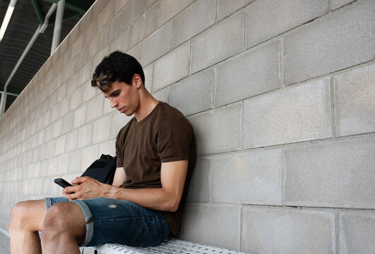 Young athlete browsing smartphone during break