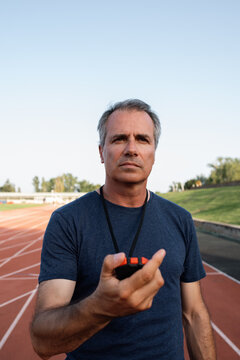 Serious coach with timer on stadium