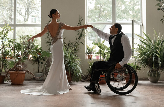 Cheerful man rehearsing wheelchair dance with graceful partner