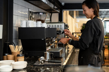 Female barista making coffee at espresso machine