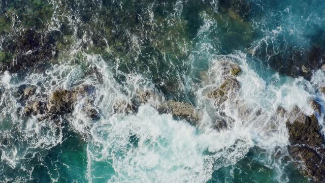 Top down aerial view of ocean waves crashing