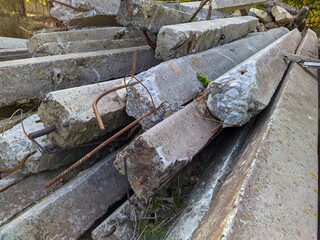 rusty metal rods sticking out of concrete pillars