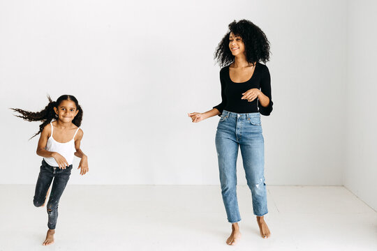 A Mother & Daughter Running Around An All White Studio.