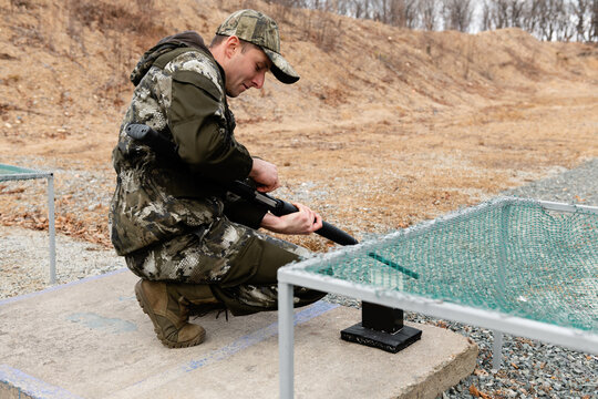 Shooter loading gun on shooting range