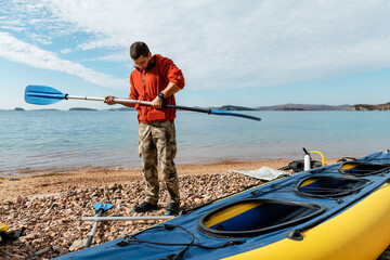 Male preparing paddle for kayaking in sea