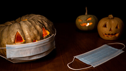 A closeup shot of a Halloween pumpkin with sanitary mask - concept of the new normal