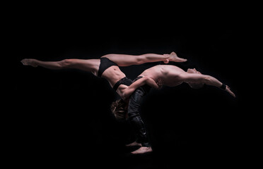 girl with boyfriend perform beautiful gymnastic elements. 
beautiful acrobatic couple. black...