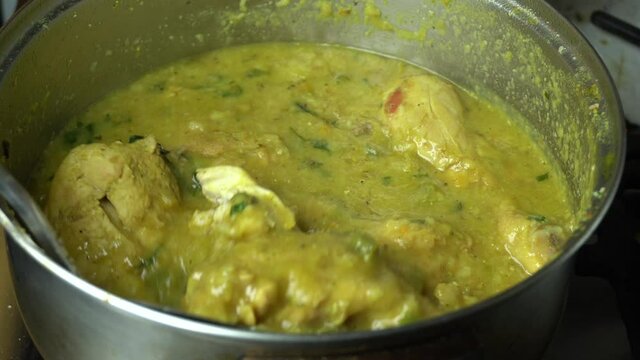 Close up removing and cooking homemade Aji de pollo in a kitchen pot. Typical peruvian food 