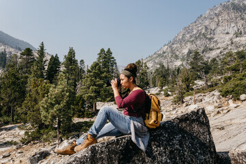 Tourist with backpack & camera hiking in mountains at Lake Tahoe in California, USA