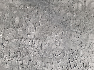Old gray wall with cracks in plaster and paint. Destruction