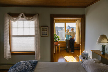Senior Citizen Couple Looking out Window at Home