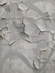 Old gray wall with cracks in plaster and paint. Destruction