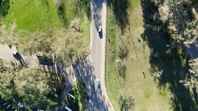 Video Time-Lapse desde un dron en plano cenital, de una intersecci&oacute;n de carreteras de tres calles, en un parque p&uacute;blico. 