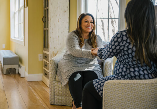 Smiling Doula Meeting with Expectant Hispanic Woman at Home