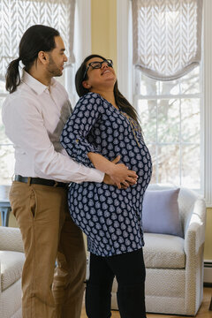 Husband and Pregnant Wife holding relaxing at Home