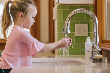 Child Washing Hands in Sink