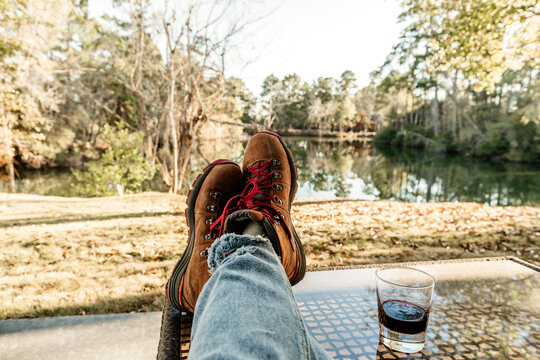 First Person View Of Feet Propped Up On A Table With A Glass Of Wine.