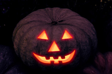 Halloween. Pumpkin Carving a jack-o'-lantern with glowing eyes and a smile in the dark, frightening design