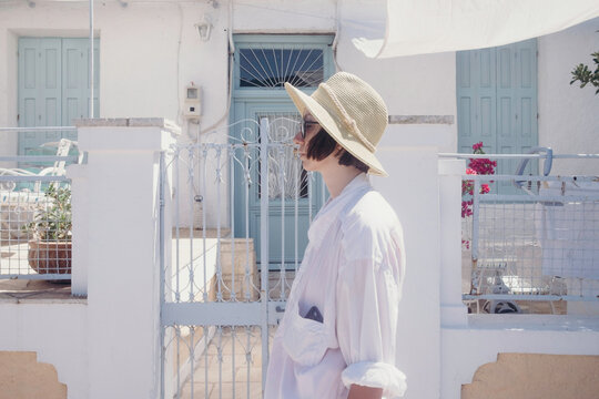Portrait of a short hair female model with sunhat on the street at Paxos Island
