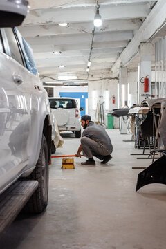 Worker washing floor in garage