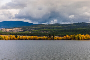 A lake and mountain view with trees changing color for the fall