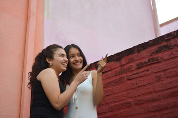 two friends smiling while pointing to the sky