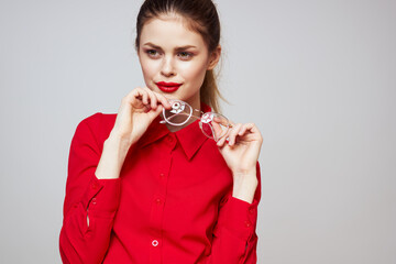 fashionable woman in a red shirt on a light background fun emotions bright makeup glasses attractive appearance 