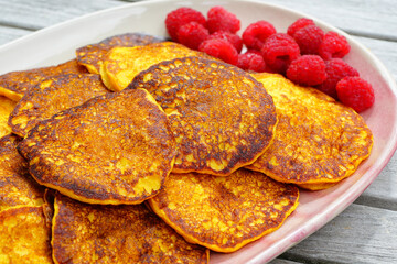 Platter of vegan pumpkin pancakes with fresh raspberries
