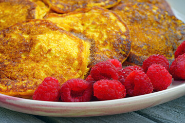 Platter of vegan pumpkin pancakes with fresh raspberries