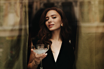 Charming lady in velvet outfit holds martini glass