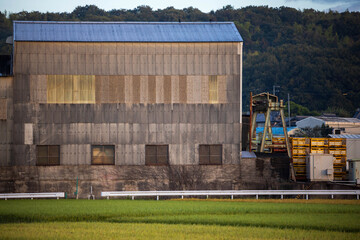 Fototapeta na wymiar Large metal storage building with crane and pallets stacked for loading