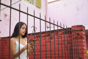 young brunette woman using cell phone with her long nails