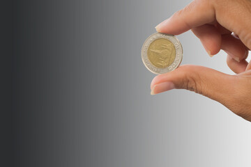 Fototapeta premium hand holding coin on blur image for inflation or failing, going bankrupt. finance concept.