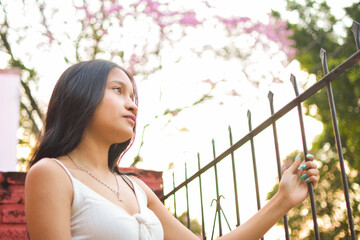 young brunette girl thinking outdoors, painted nails