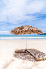 Beach Umbrella made of palm leafs on a perfect white beach in front of Sea in Thailand.