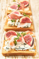 bruschetta with blue cheese, prosciutto and fresh figs, selective focus.