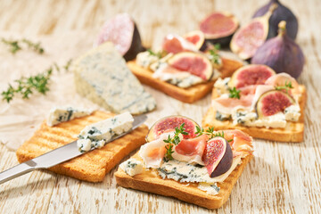 cooking breakfast, sandwiches with blue cheese ham and fresh figs, on a white kitchen table.